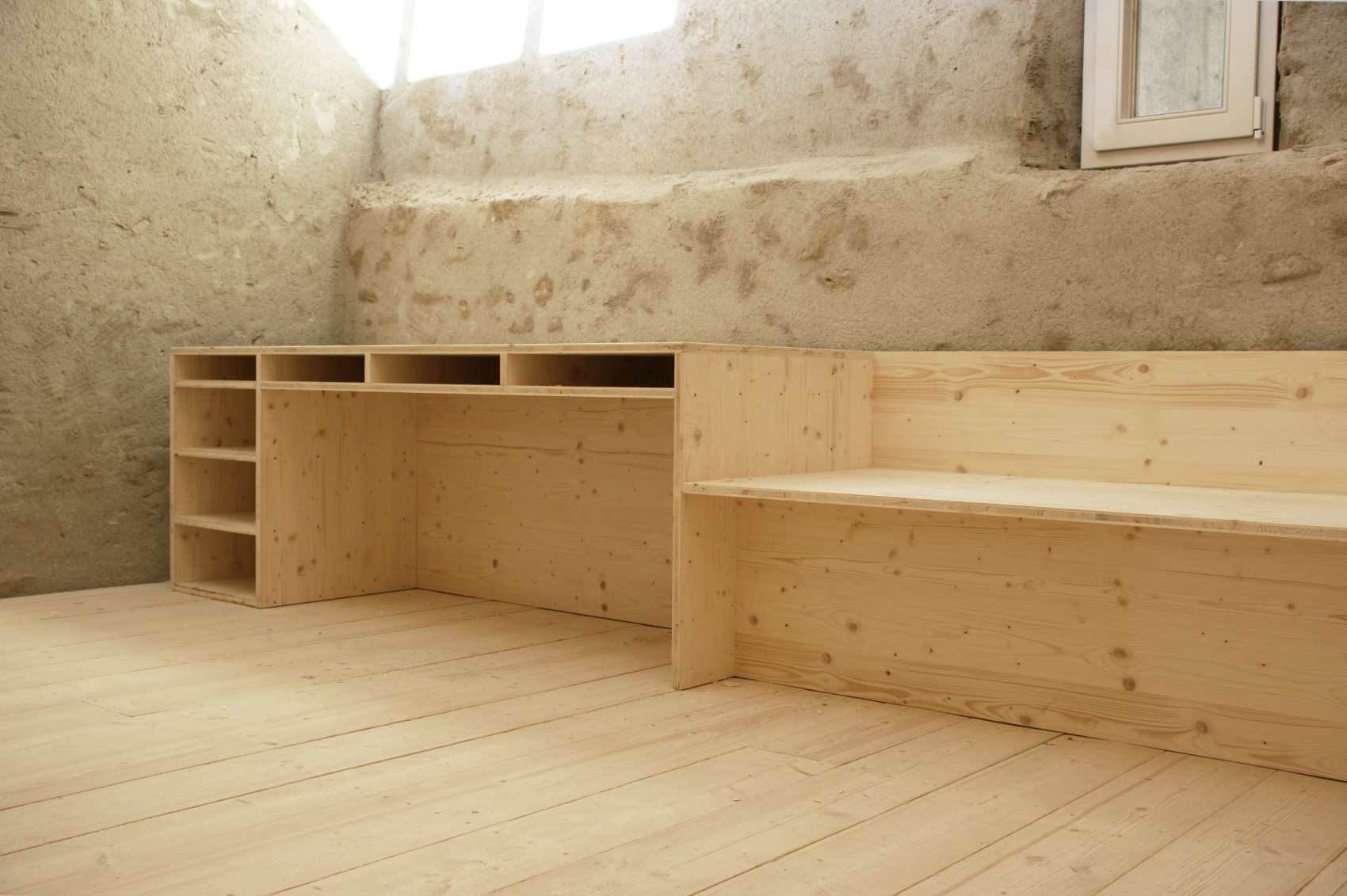 Ausgebauter Raum mit Bruchsteinwand, Holzboden und Einbauregalen