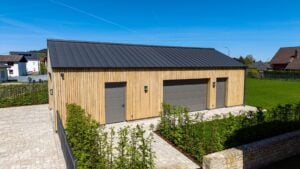 Holzgebäude mit vertikaler Fassade und Garagentor auf einem Grundstück