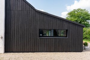 Anbau mit dunkler Holzfassade und Fensterband