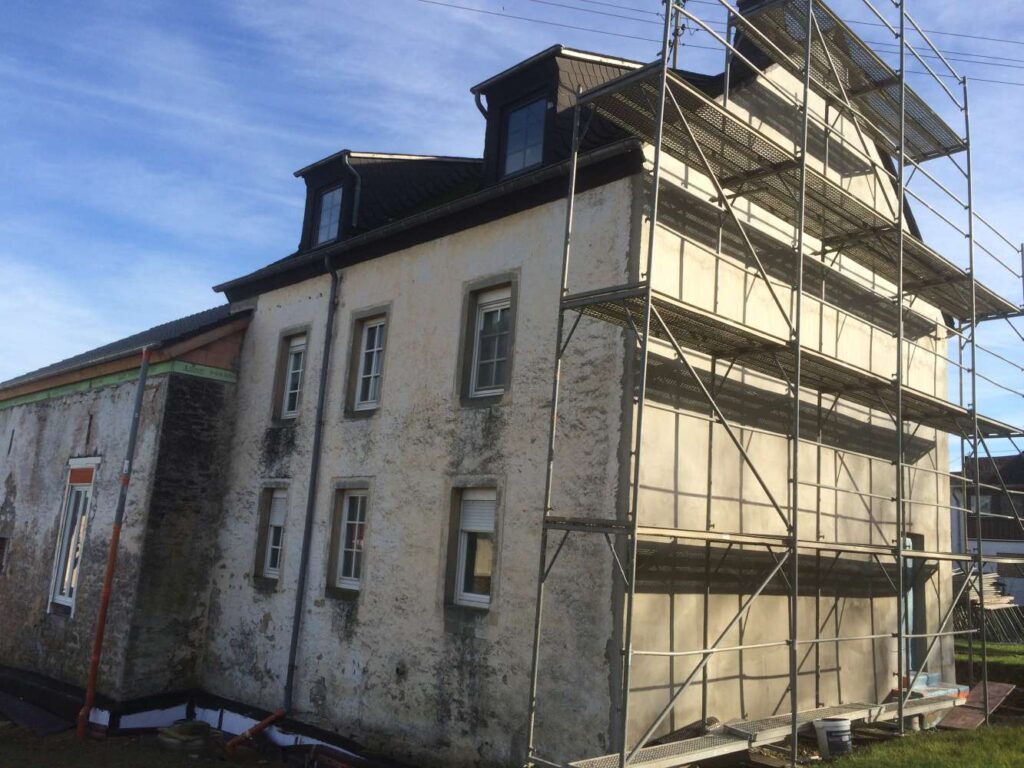 Altes Bruchsteinhaus mit Gerüst während der Fassadensanierung
