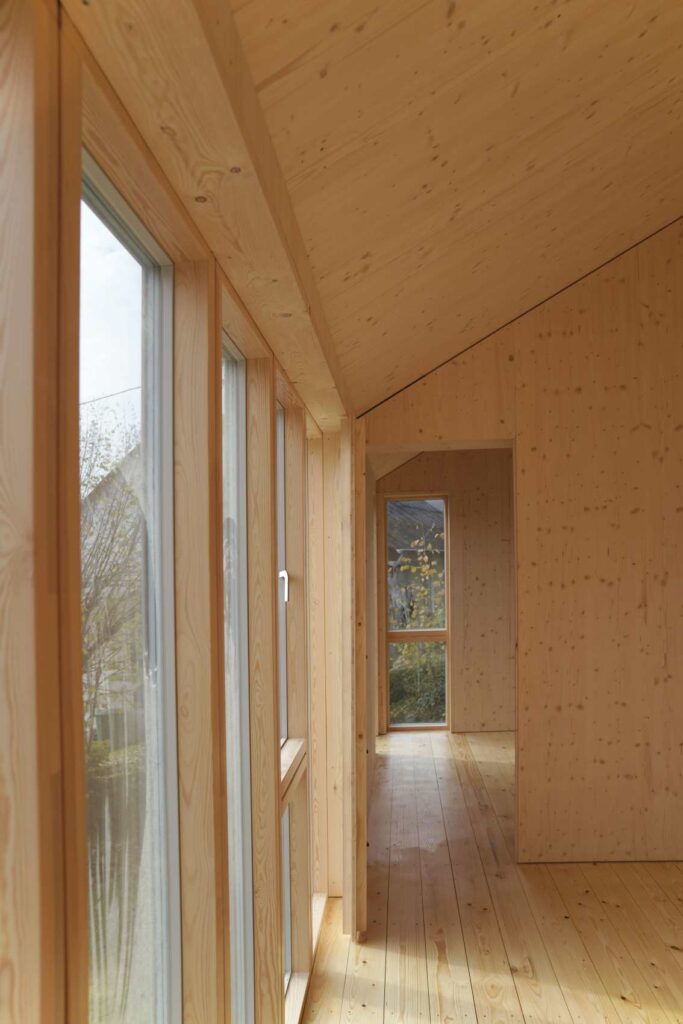 Heller Innenraum eines Holzbaus mit großer Verglasung