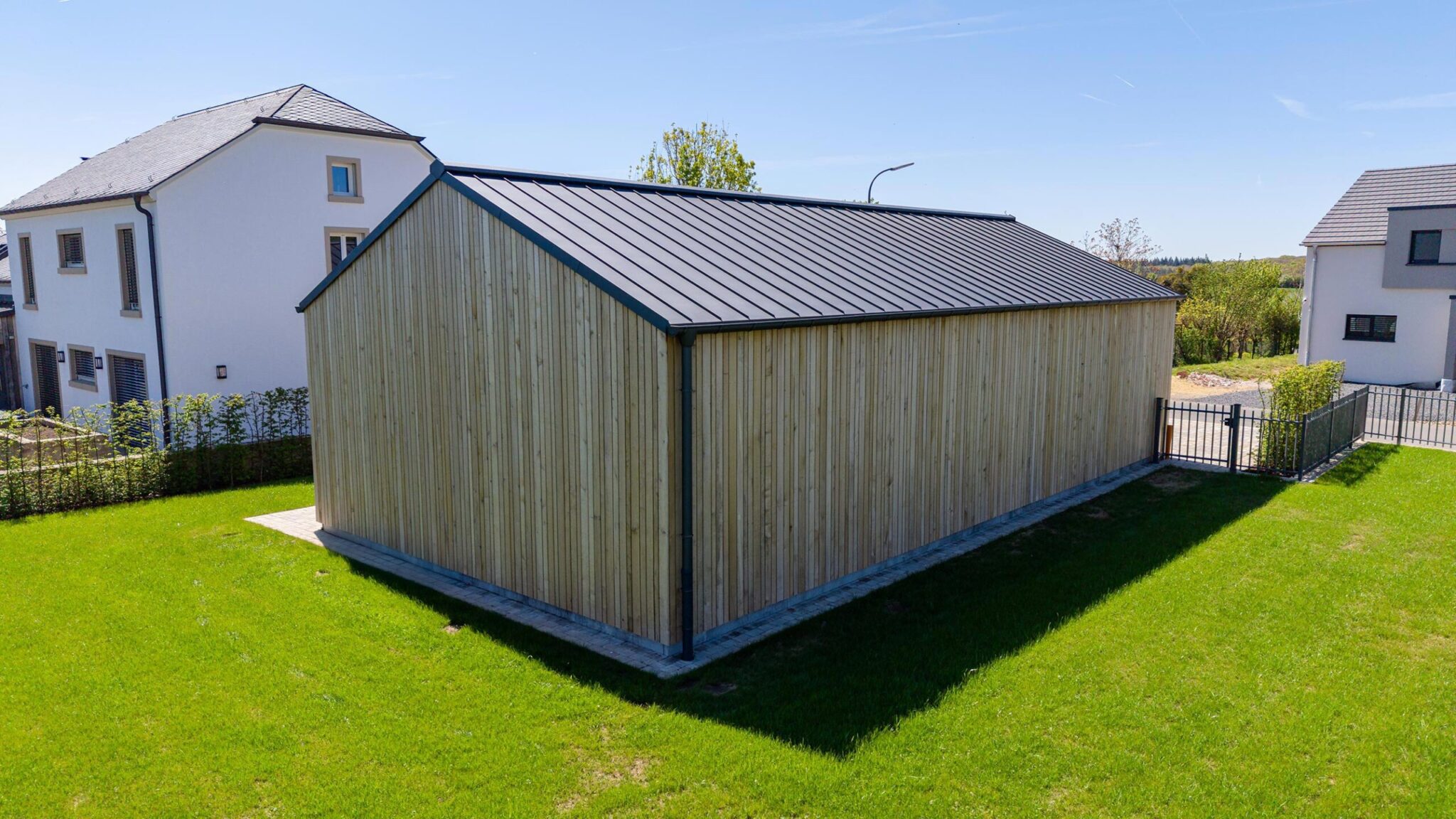 Nebengebäude in Holzbauweise mit Lärchenfassade in einer Wohnsiedlung in Luxemburg