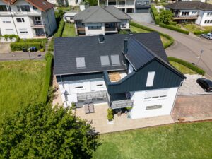 Vue aérienne d'une maison individuelle avec une nouvelle extension de toit en construction en bois