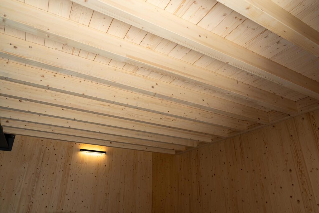 Innenraum einer Garage in Brettsperrholzbauweise mit sichtbarer Balkendecke