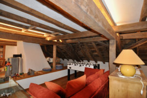 Living space with visible wooden beams and sofa after the renovation