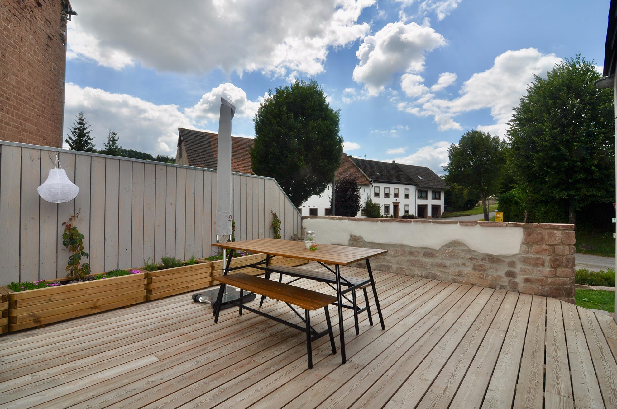 Holzterrasse mit Sitzbank und Pergolapfosten