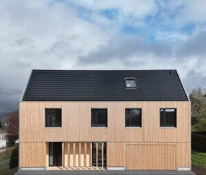 Holzhaus mit senkrechter Lärchenschalung und dunklem Satteldach
