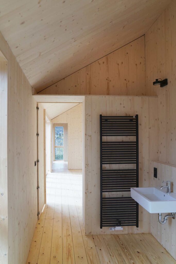 Innenraum eines Holzbaus mit sichtbaren Massivholzwänden und Holzdecke