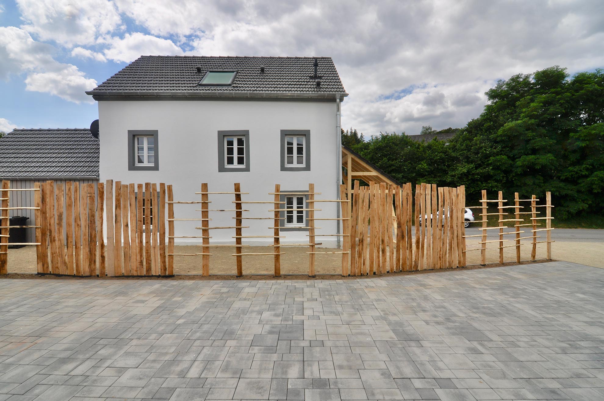 Neue Holzterrasse vor einem weißen Einfamilienhaus