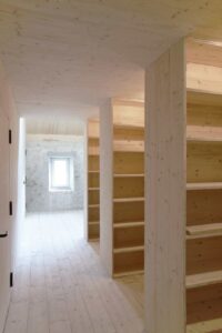 Heller Flur mit Holzregalen und Durchgang