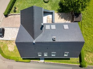 Extension du toit avec un nouveau toit plat et des fenêtres vitrées depuis le ciel