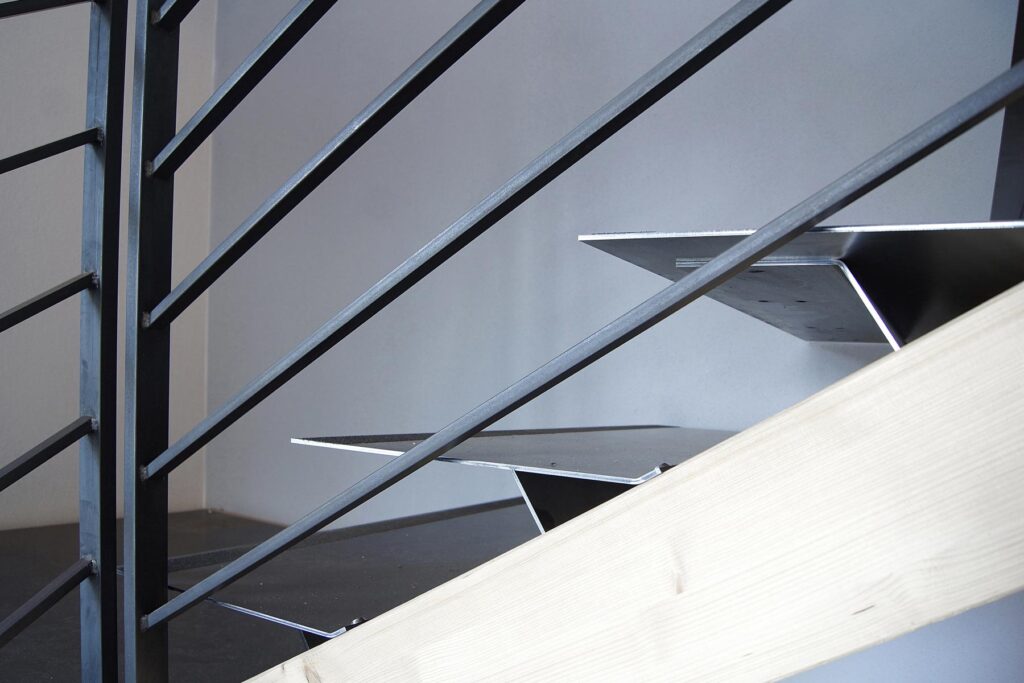 Treppendetail mit Stahlgeländer, Stahlstufen und Holzwange