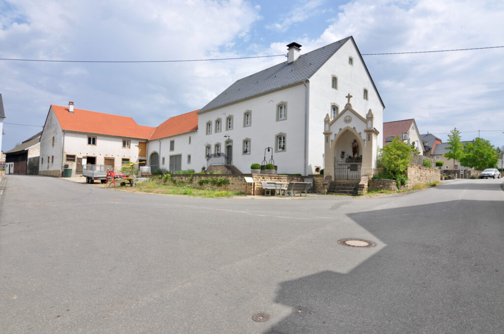 Eifeler Dorfplatz mit weißem Bauernhaus