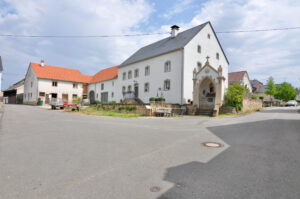Eifel village square with a white farmhouse