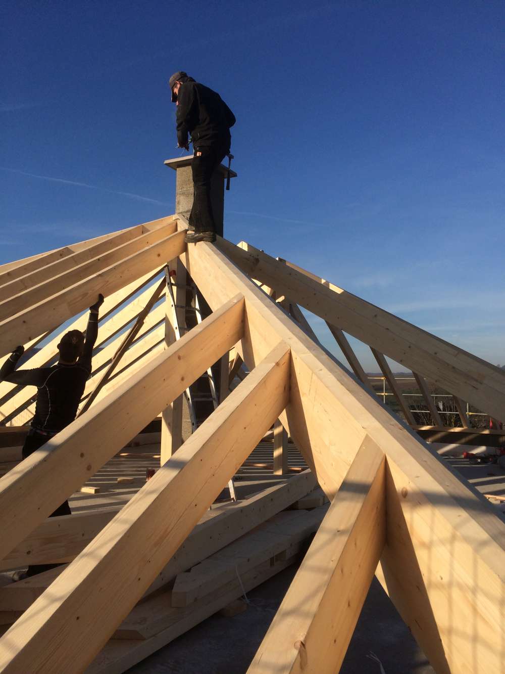 Zimmerer during the assembly of a wooden roof beam