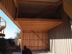 Structure en bois avec des poutres visibles et un système de charpente