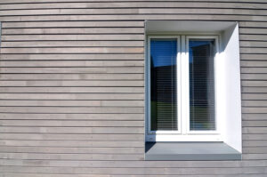 Façade en bois horizontale avec des fenêtres après la mise en œuvre de l’isolation de la façade