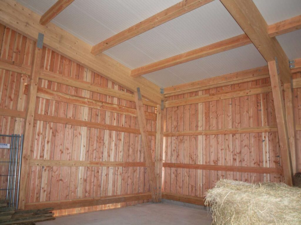 Innenraum der Lagerhalle mit Holzverschalung und Strohballen