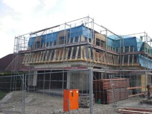 Eingerüstetes Wohnhaus mit neuem Holzdachstuhl für den Dachausbau