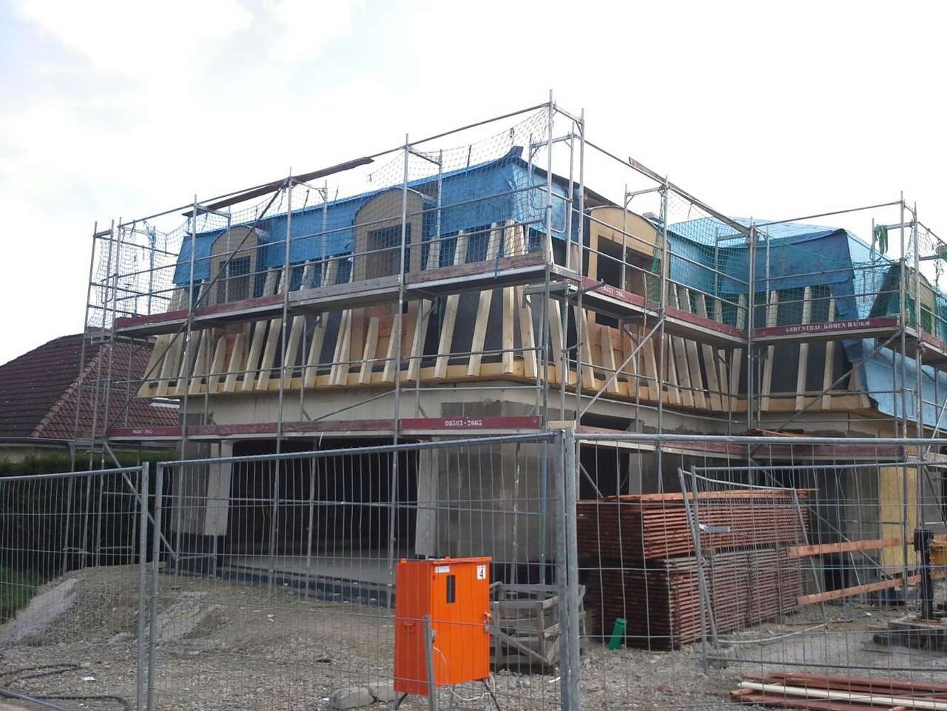 Eingerüstetes Wohnhaus mit neuem Holzdachstuhl für den Dachausbau