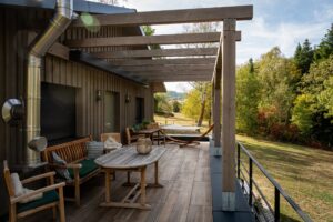 Überdachte Terrasse mit Holzpergola und Sitzgruppe