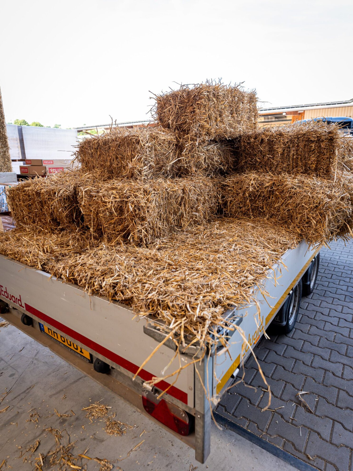 Strohballen auf einem Anhänger vor der Abbundhalle