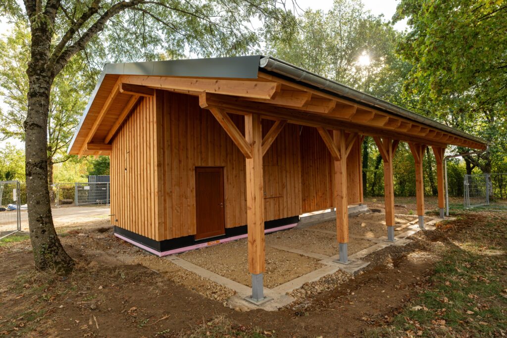 Holzchalet mit überdachtem Unterstand im Park