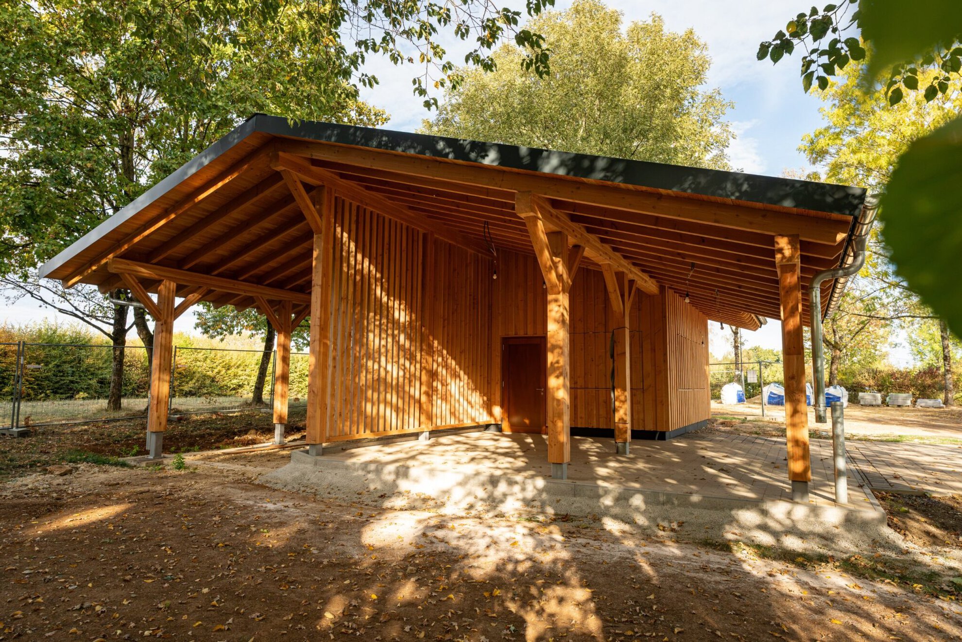 Überdachter Unterstand des Chalets mit Holzstützen und Kopfbändern