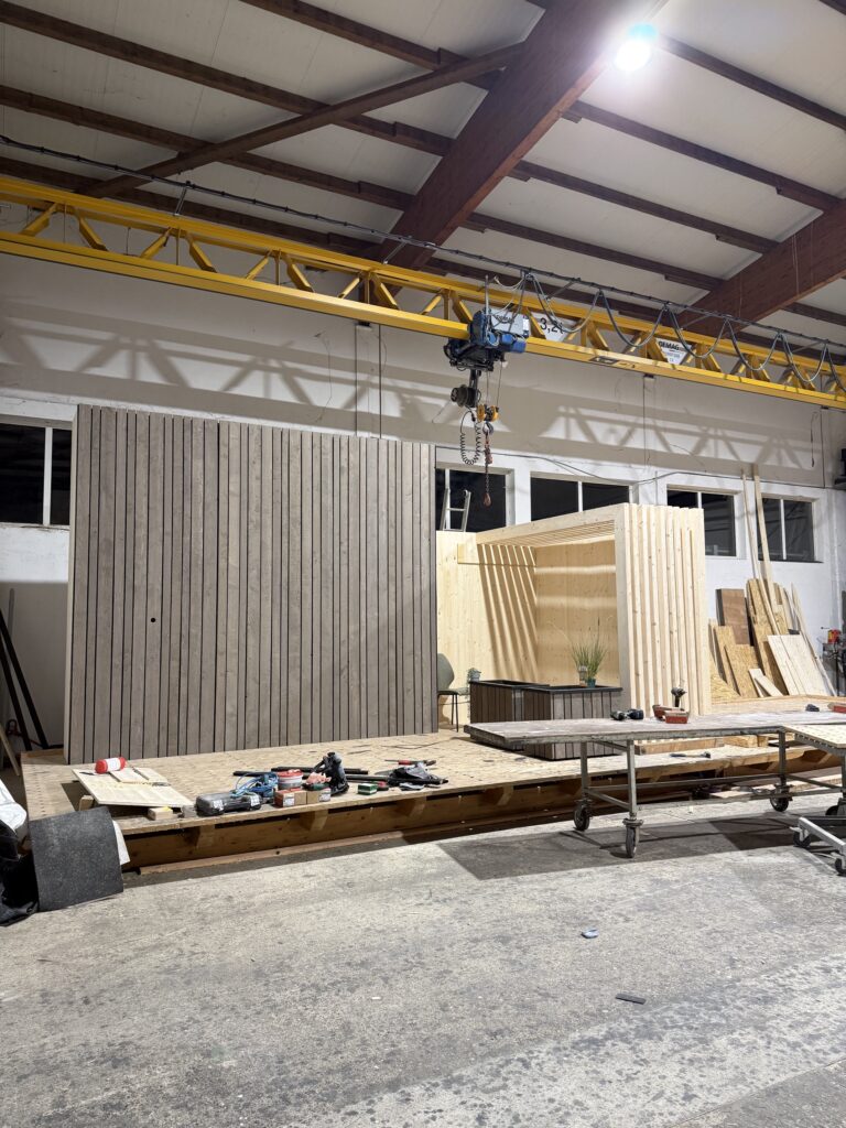 Rückwand und Sitznische des Messestands unter dem Hallenkran