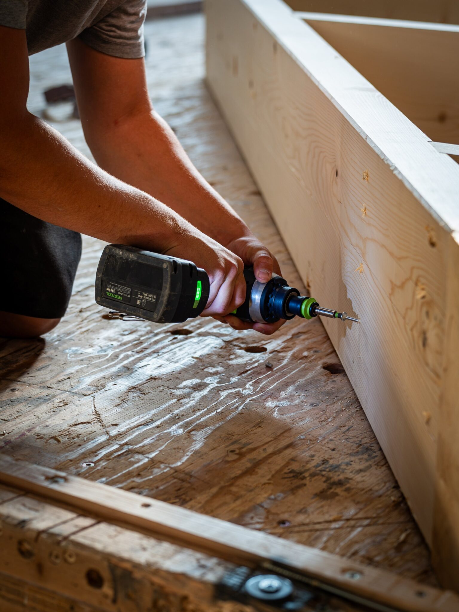 Zimmerer verschraubt ein Holzrahmenelement für das Strohhaus